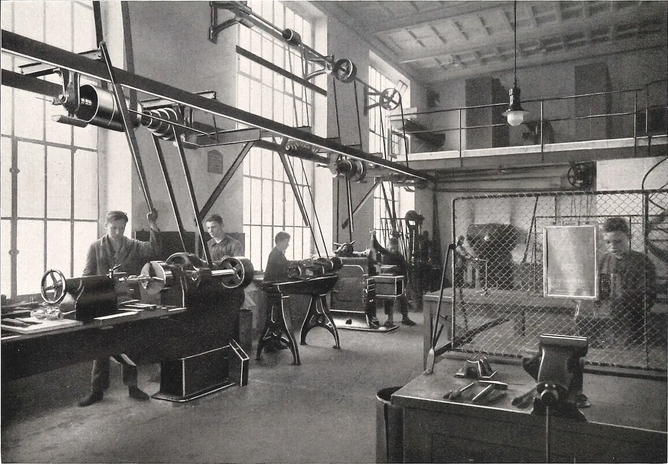 Metal işleme atölyesinde makineler üzerinde çalışan çıraklar.